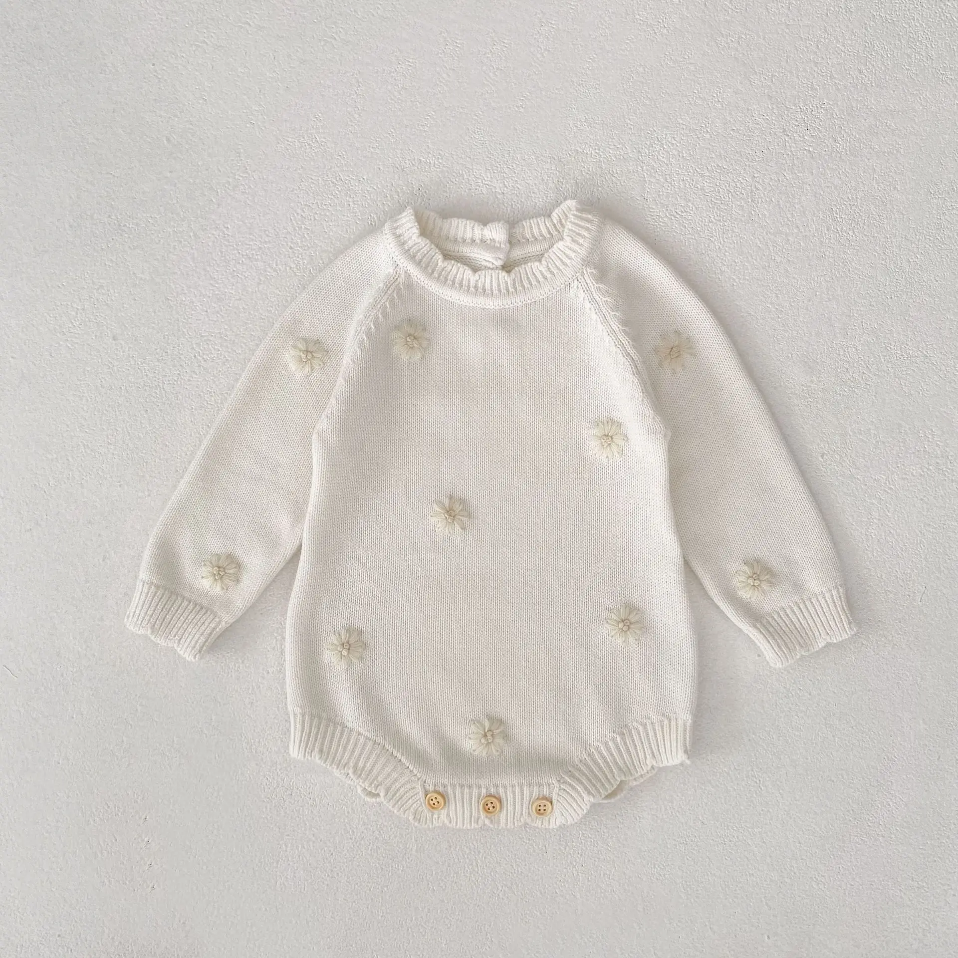 Barboteuse tricot crème pour bébé motifs floraux
